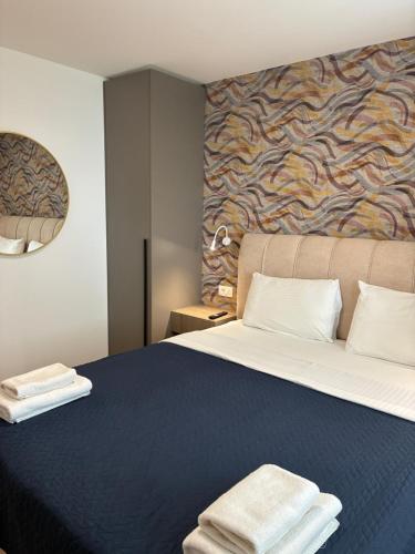 a bedroom with a large bed with two towels on it at Apartments Malic in Petrcane