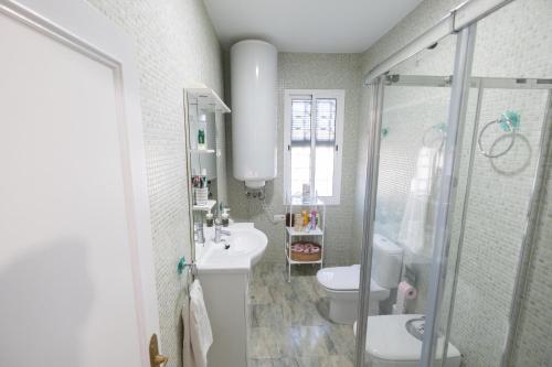 a bathroom with a toilet and a sink and a shower at Chalet las Pajanosas in Guillena