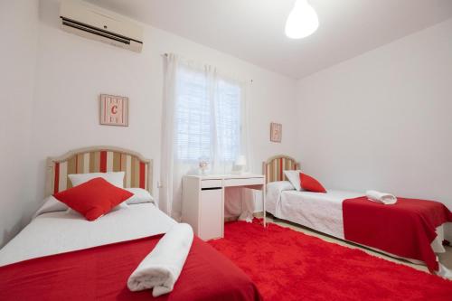 two beds in a room with a red carpet at Chalet las Pajanosas in Guillena