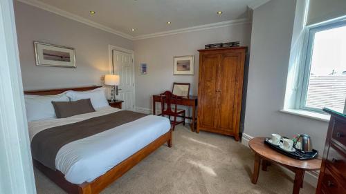 a bedroom with a bed and a table and a window at The Redstone Guesthouse in Blackpool