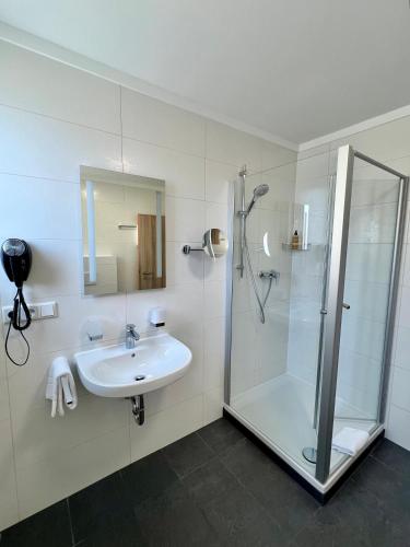 ein Badezimmer mit Waschbecken und Dusche in der Unterkunft Hotel Fantasie in Ansbach