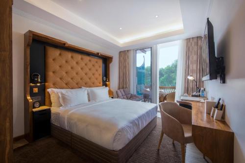 a hotel room with a bed and a desk and a room with a desk at The Radh Hotel in Kandy