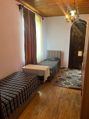 a bedroom with two beds and a window and a chandelier at Chavchavadze 56 in Kobuleti