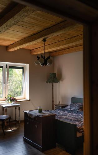 a bedroom with a bed and a wooden ceiling at Domek Pod Strzegominą in Szerzyny