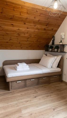 a bed in a room with a wooden ceiling at Zacisze nad Orlicą in Międzylesie