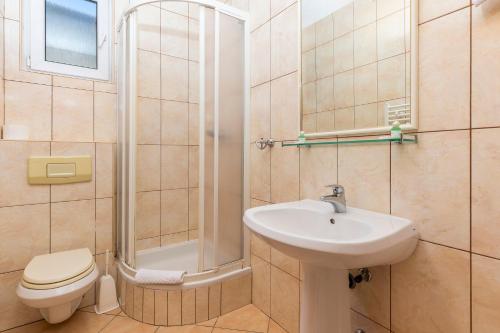 a bathroom with a sink and a shower and a toilet at Guesthouse Villa Adria in Malinska