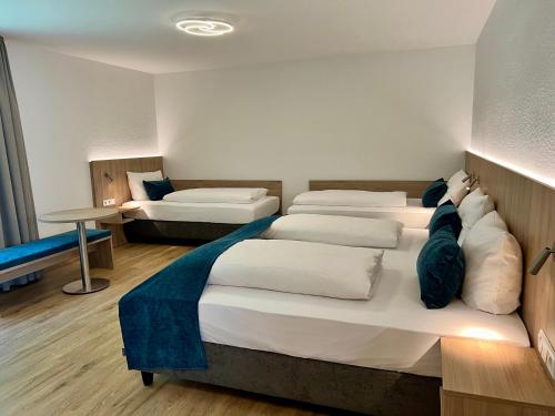 ein Hotelzimmer mit vier Betten und ein Zimmer mit einem Bett istg in der Unterkunft Hotel Fantasie in Ansbach