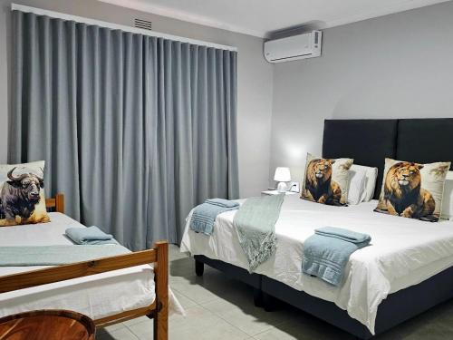 a bedroom with two beds with lions on the pillows at Wave Dancer 2-Bedroom Apartment in St Lucia
