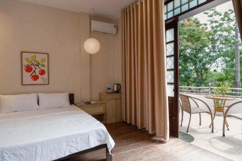 a bedroom with a bed and a table with chairs at Tổ Homestay in Thôn Kim Long (1)