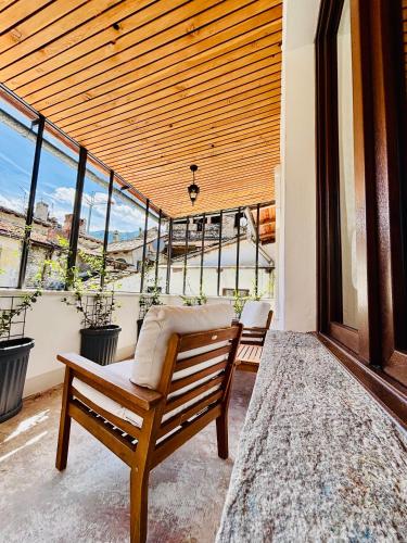 a wooden bench sitting on a balcony with windows at Corte Gelsomino in Susa