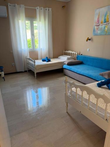 ein Wohnzimmer mit zwei Betten und einem blauen Sofa in der Unterkunft Ipsos apartment in Ýpsos