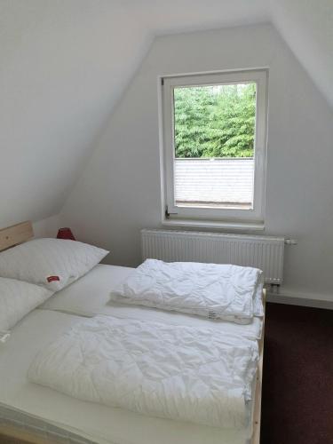 a bedroom with a white bed and a window at Sauberghaus Wohnung 3 in Breitenbrunn