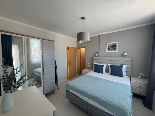 a bedroom with a bed with blue pillows at Turtle Apartment Sunny Beach in Sunny Beach