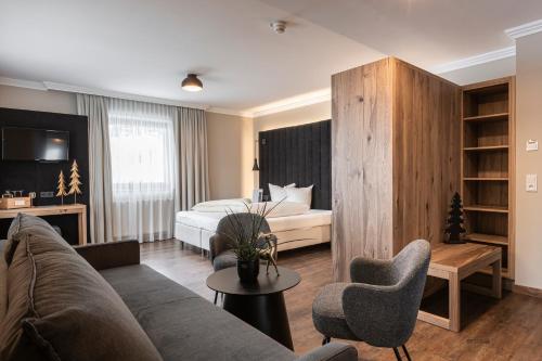 a living room with a couch and a bed in a room at Hotel Gramaser in Ischgl