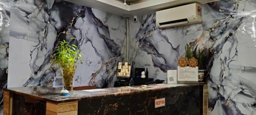a room with a marble wall with a counter with a vase at NOVA HOTEL Bukit Bintang in Kuala Lumpur