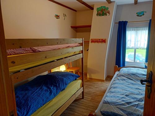 a bedroom with two bunk beds and a window at Ferienhof van Vlyten_ 45006 in Jemgum
