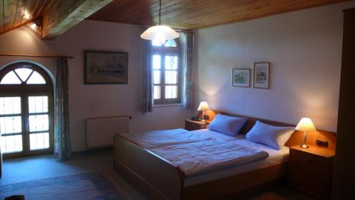 a bedroom with a bed with two lamps and a window at Schneiderhof in Rimsting