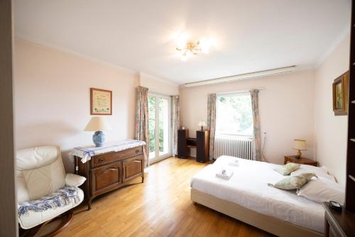 a bedroom with a bed and a couch and a chair at Maison Bellevue in Brunstatt