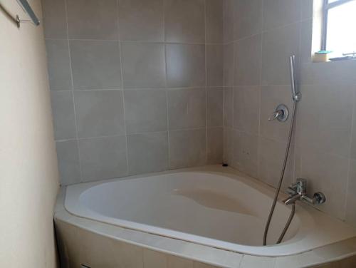 a bath tub in a bathroom with a shower at WilN Apartments in Francistown