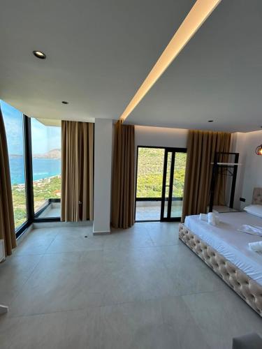 a bedroom with a bed and views of the ocean at Borsh sunset apartments in Borsh