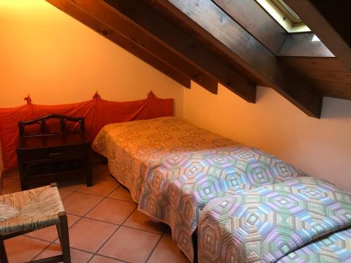 a bedroom with a bed and a chair in a room at Casaria da Adry in Cannobio