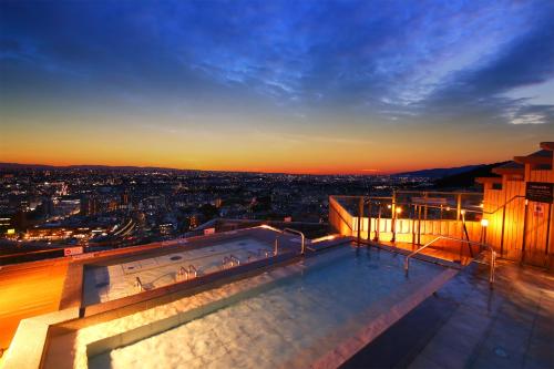 a view of the city at night from a building at Ooedo Onsen Monogatari Premium Minoh Kanko Hotel in Minoo
