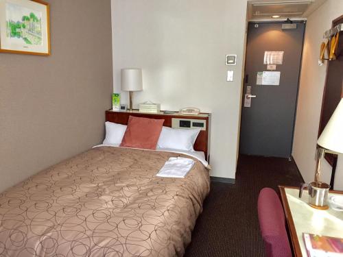 Hotel Sunroute Fukushima في فوكوشيما: غرفة فندق بسرير في غرفة