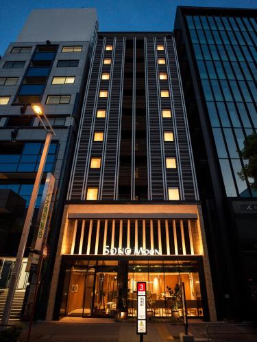 a tall building with a sign in front of it at SONO Moon Nagoya in Nagoya