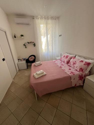 a bedroom with a pink bed with a pink blanket at Il Corallo in Terracina