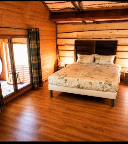 a bedroom with a bed in a log cabin at Cabane Des Boiseries in Esnans