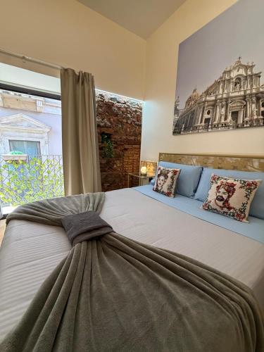 a bedroom with a large bed and a large window at Duomo View Apartment in Catania