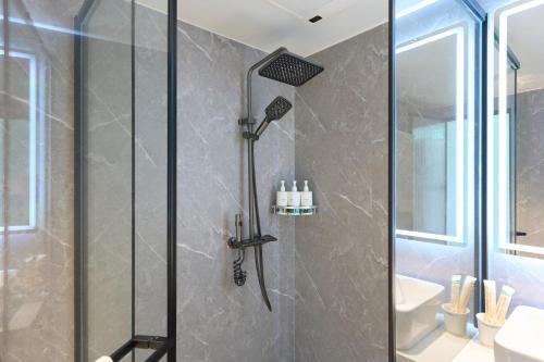 a shower with a glass door in a bathroom at Straddie Island in Niseko