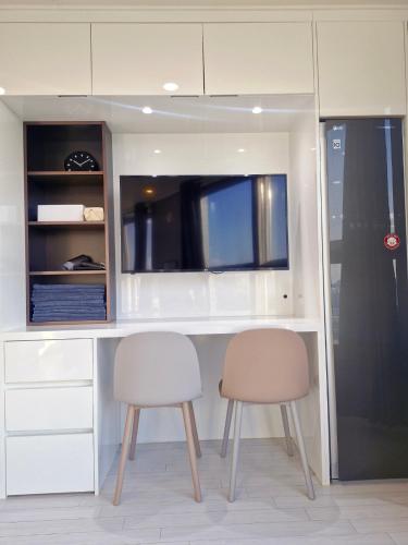 a kitchen with two chairs and a desk with a tv at Sj라벨라 강서 in Samgong