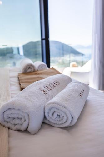 a row of white towels sitting on a bed at ELGIAN Luxury Villa -Private Pool & Sea View in Póndi