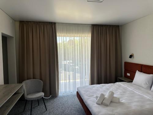 a hotel room with a bed and a desk and a window at HILLIUS Resort in Solotvyno