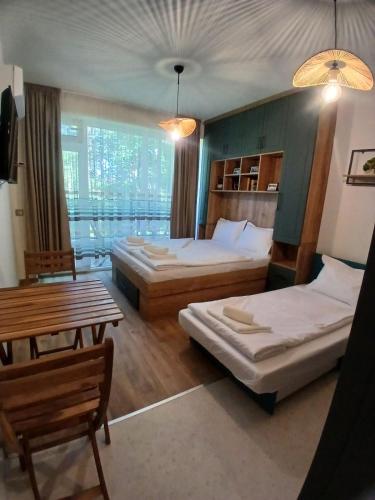 a hotel room with two beds and a table at Studio ONE in Kiten