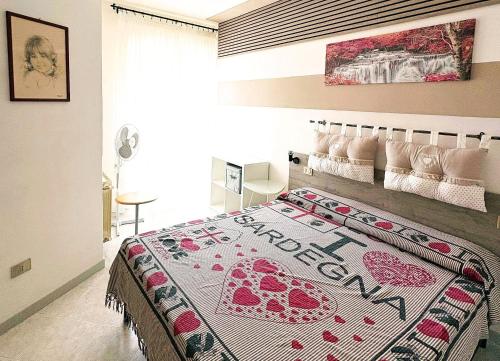 a bedroom with a bed with a red and white blanket at VILLA ROSSINI in Valledoria