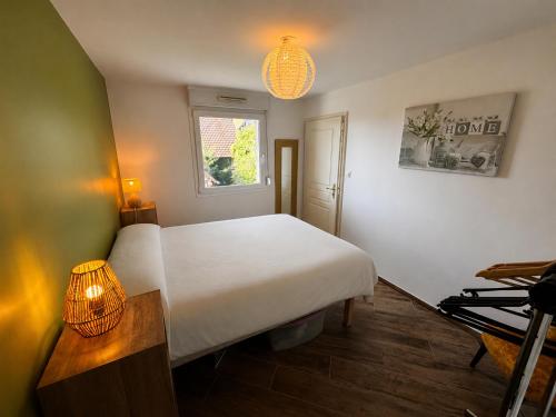 a bedroom with a white bed and a window at A Chatenois le Repère d'Anna in Châtenois