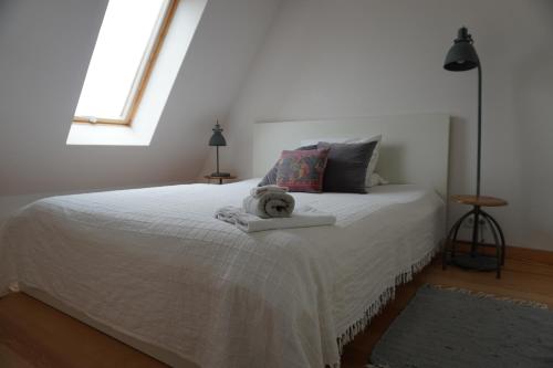 a bedroom with a white bed with a teddy bear on it at Lerchenhof in Balingen