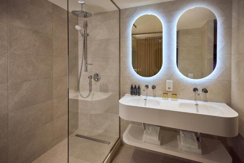 a bathroom with a sink and a shower at WestCord Hotel Eindhoven in Eindhoven