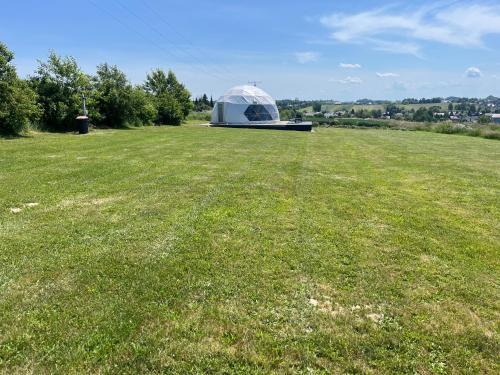 a large field with a tent in the middle of a field at Glamp Ojcowska in Jerzmanowice