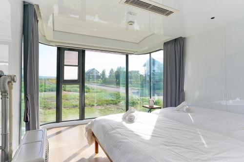 a bedroom with a bed and a large window at Straddie Island in Niseko