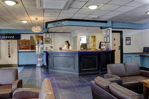 a woman standing at a bar in a waiting room at Hotel St Pierre, Sure Hotel Collection by Best Western, Newmillerdam, Wakefield in Wakefield