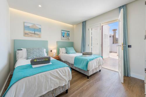 a bedroom with two beds and a sliding glass door at Apartment Vistamar IV in Port de Pollensa