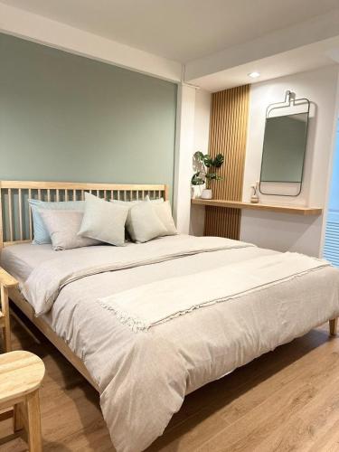 a bedroom with a large bed with a tv on the wall at O2 Bangsaen in Ban Bang Saen (1)