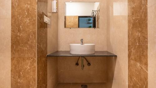 a bathroom with a sink and a mirror at Z Stays, Silkboard in Bangalore