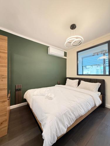 a bedroom with a large white bed with a window at Top Centre Apartment 5 mins to beach in Burgas