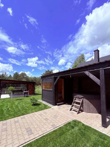 a house with a patio and a wooden building at 10 osobowy Bania House Okuninka rowerek wodny jacuzzi sauna 1200 m do centrum Okuninki 6 km do Włodawy in Włodawa