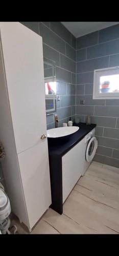 a bathroom with a white sink and a toilet at Chez JP & NATH in Alcossebre