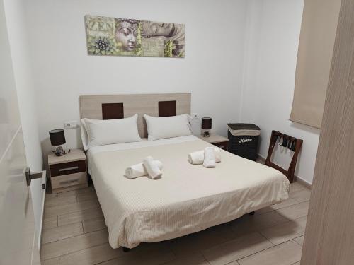 a bedroom with a bed with towels on it at Bioparc Metro Valencia in Valencia